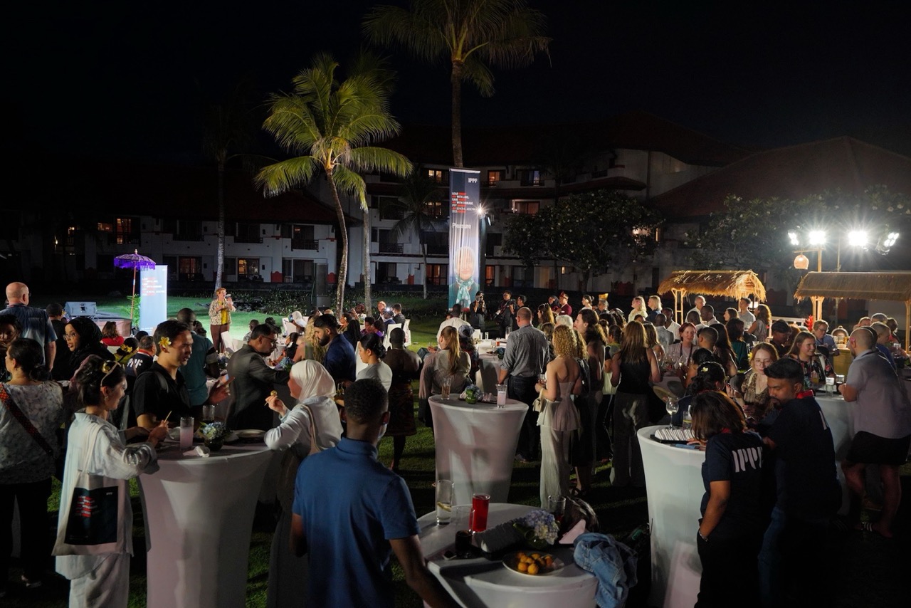 International conference delegates networking during an evening outdoor reception in Bali