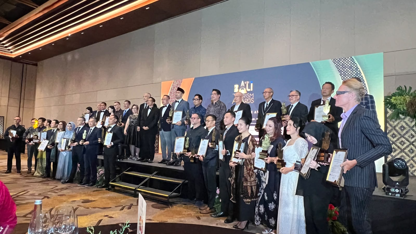 Recipients and tourism leaders gathered on stage at the 11th Bali Tourism Awards at Bali Beach Convention Center